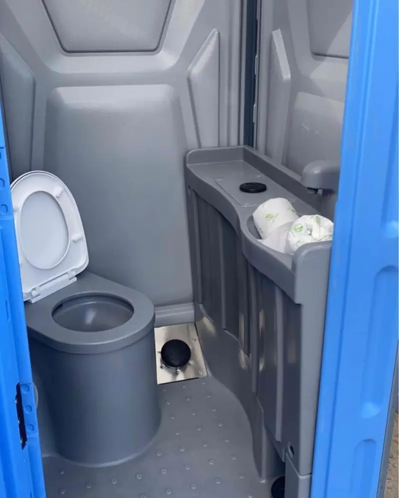 Inside a deluxe flushing portable restroom with flush toilet and built-in sink