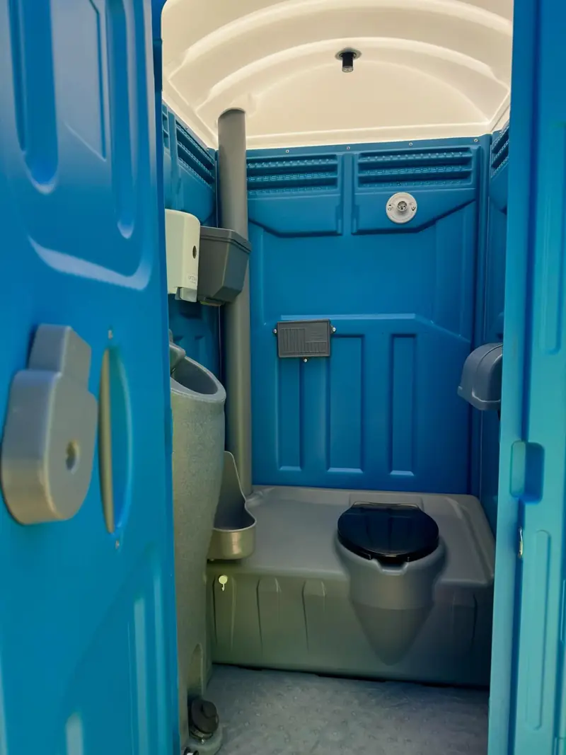 Interior of a portable toilet with vent, mirror and dispensers