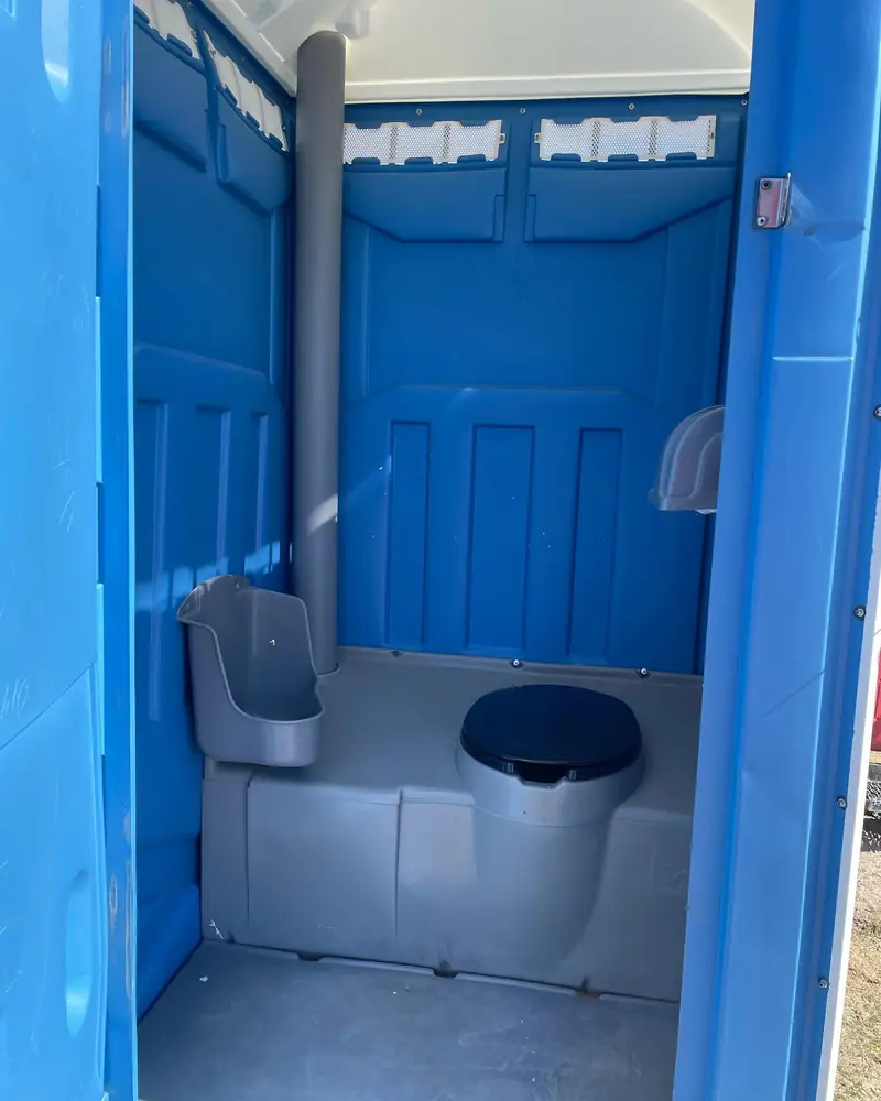 Inside a standard portable toilet: seat, urinal and toilet paper holder