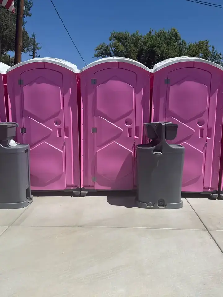 Five pink event portable toilets with two hand washing stations
